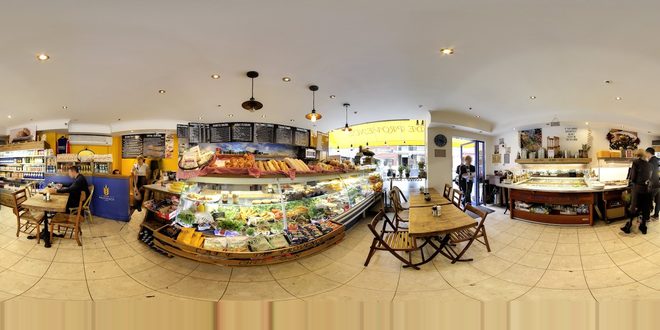 Wide interior of the cafe with the curved deli counter and seating