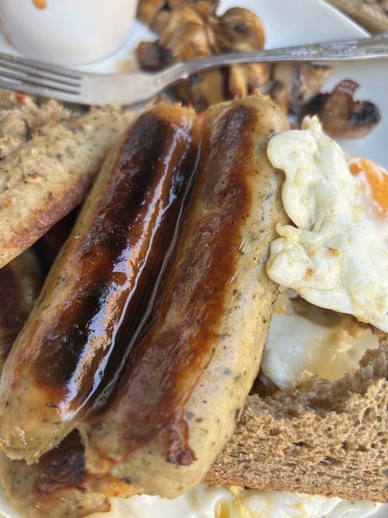 Sausages, a fried egg and mushrooms served on toast