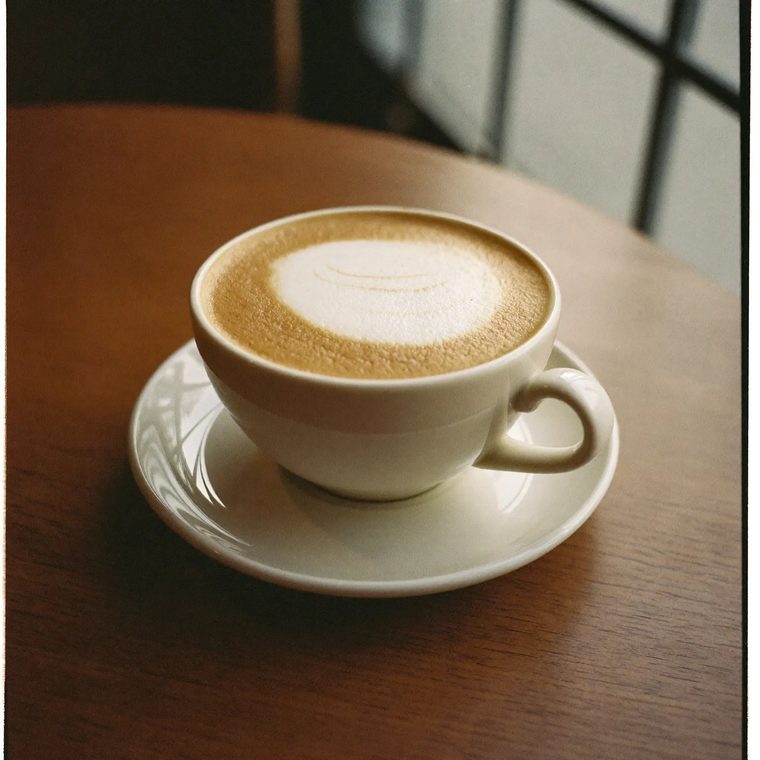A cappuccino in a white cup on a wooden table