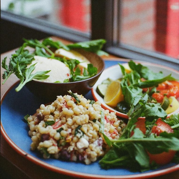 A plate of mixed deli salads on a wooden table